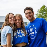 Three students pose for a picture during tailgate.